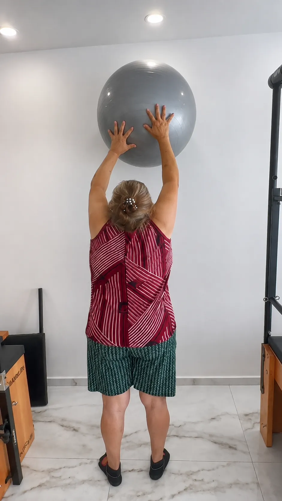 Aluna realizando exercício de mobilidade com bola no Studio